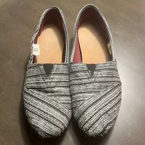 Lightly loved TOMS black and silver slip on